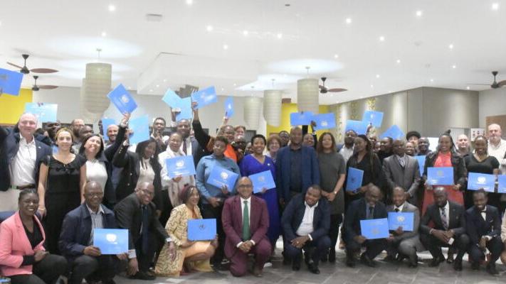 SADC ERT Induction participants in Botswana cheer in a group photo with their certificates