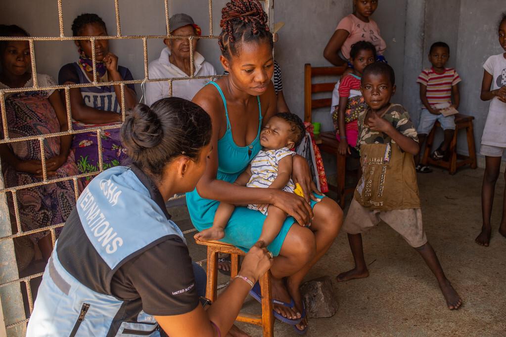 UNDAC team member interviewing mother and child
