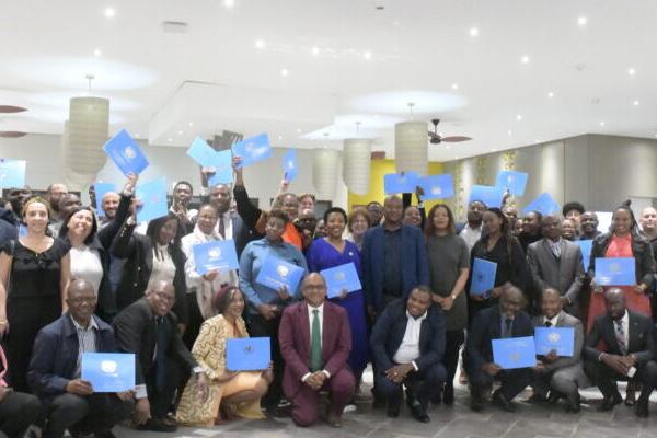 SADC ERT Induction participants in Botswana cheer in a group photo with their certificates