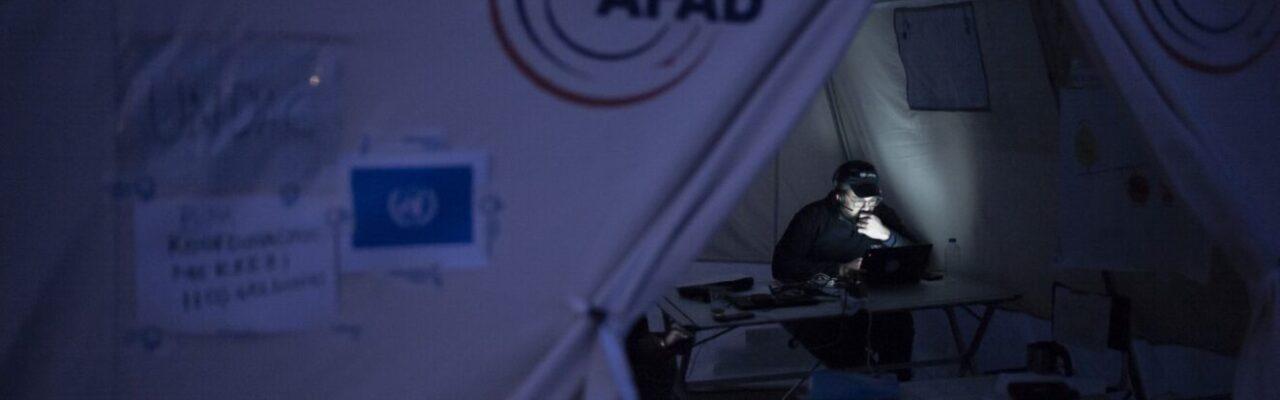 UNDAC team member working in the lamp light at night